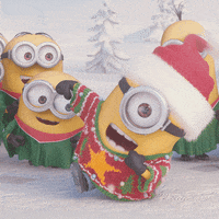 Movie gif. A Minion from Despicable Me excitedly hops and dances around in an ugly Christmas sweater and Santa hat. Several other minions, dressed in green choir gowns, sway back and forth or copy him as they sing along.