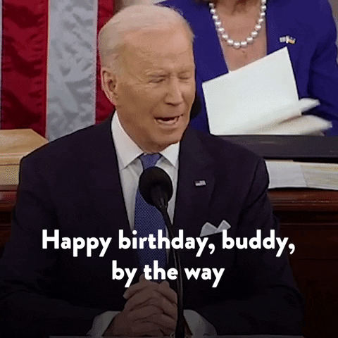 Politics gif. Joe Biden behind a microphone looks off to the side and says, "Happy birthday, buddy, by the way," which appears as text.