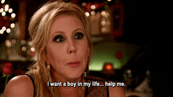 Reality TV gif. Vicki Gunvalson from Real Housewives of Orange County is chatting with someone at a restaurant and she stares at them while saying, "I want a boy in my life.. help me."