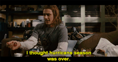 Movie gif. James Franco as Saul Silver in Pineapple Express sits on a couch, eating something while he cattily says, "I thought hurricane season was over."
