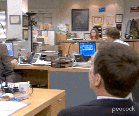 The Office gif. While John Krasinski as Jim and Jenna Fischer as Pam sit at their desks in the background, Ed Helms as Andy spins around in his desk chair to wink at us.