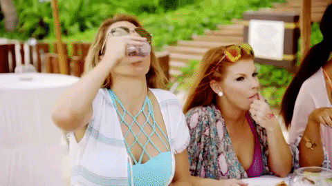 Gif s ženami pijícími alkohol na zahradě restaurace.