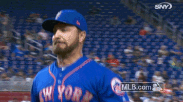 Sports gif. Josh Smoker of the New York Mets wears his team uniform and grimaces as he jogs on the field.