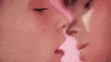 Video gif. Teenage boy and girl lean in for an intimate kiss; the girl reaches out for the boy’s neck as the boy runs his fingers behind her ear.