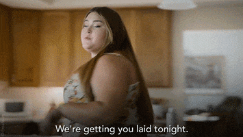 TV gif. Lily Mae Harrington as Felicia in Single Drunk Female paces in a kitchen with urgency, stops in front of a friend, and says "we're getting you laid tonight," which appears as text.