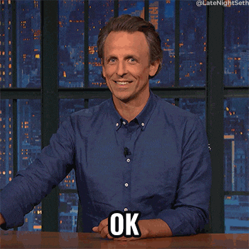 Late Night gif. Seth Meyers shrugs and tucks his chin in as he throws up a hand and says, "Ok."
