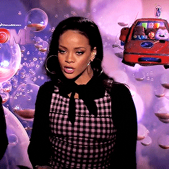Celebrity gif. Rihanna moves her head side to side to dance, and purses her lips as she gets into it. The poster for the movie Home is behind her.