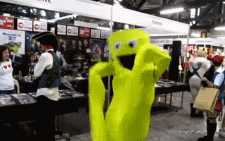 Video gif. A "wacky waving inflatable arm-flailing tube man" does its thing in the middle of a convention.
