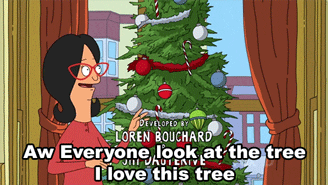 Cartoon gif. Linda Belcher on Bob’s Burgers stands next to a Christmas tree and happily looks around and up at the tree as she says, “Aw everyone look at the tree. I love this tree.”