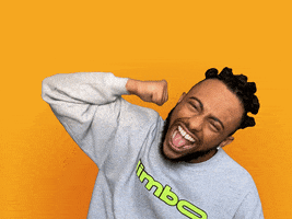 Celebrity gif. Wearing a gray sweatshirt on a solid yellow background, Amine seems to be cheering us on as he excitedly does a rotating arm pump. White cartoon lines appear around his arm for emphasis.