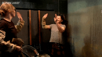 Reality TV gif. Two women on Blown Away high five each other twice in excitement.