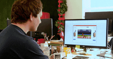 Ad gif. Employees at Sleeping Giant Media raise their hands from their desks, including an eagle head mascot.