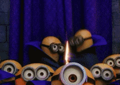 Despicable Me gif. Group of minions stare out at us as two in the back pull open a blue curtain; light pours in and two minions hold up a cake topped with the numbers 357, below a banner that reads happy birthday.
