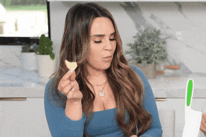 Video gif. A spooked Rosanna Pansino drops her food and backs up in surprise.