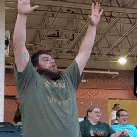 Video gif. A man stands with his arms raised excitedly as he cheers. Text runs and races on the screen, "Woo, Yeah!"