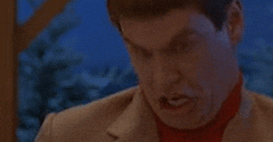 Movie gif. Jim Carey as Lloyd in "Dumb and Dumber" makes an absurd retching facial expression and gesture, bucking his neck forward and curling his lips over his teeth and then clenching his jaw.