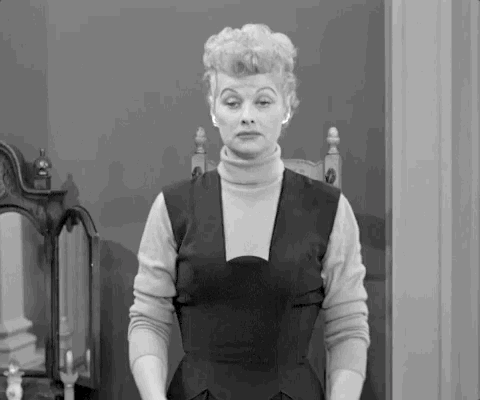 TV gif. Lucille Ball as Lucy puts her arms out to the side in an exaggerated shrug as she raises her eyebrows with a frown like, "I don't know and it doesn't bother me."