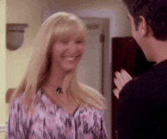 Friends gif. Lisa Kudrow as Phoebe Buffay bounces side to side with a big excited smile on her face. 