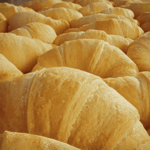 Sponsored gif. The Pillsbury Doughboy, in his iconic blue scarf and Pillsbury chef hat, pops up in front of an image of crescent rolls. Text: "Turkey Time" 