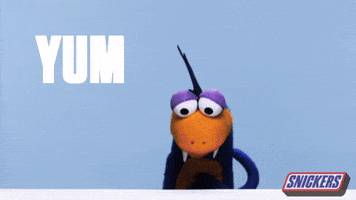 Ad gif. A Lizard-like puppet looks at us, smacking his lips, and rubbing his hand on his tummy. TExt, “Tum.” The Snickers logo is in the corner.