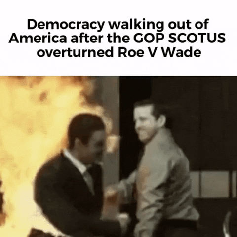 Video gif. Man walks out of a building with his suit on fire, shaking hands with a man walking into the building. Caption, “Democracy walking out of America after the GOP SCOTUS overturned Roe v. Wade.”