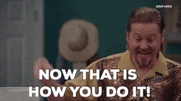 TV gif. Tim Heidecker from Tim and Eric with slicked-back blonde hair and a sparkly shirt, pointing and gesturing excitedly. Text, "Now that is how you do it!"