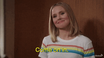 TV gif. Actor Kristen Bell of The Good Place sweetly smiles and says "Come on in" while beckoning with her head.