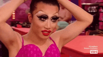 Reality TV gif. Yuhua Hamasaki on RuPaul’s Drag Race ties up her hair and smiles at us, fabulous sparkling makeup and long lashes accentuating her eyes.