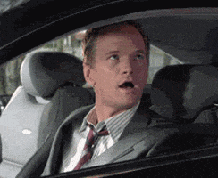 TV gif. Neil Patrick Harris as Barney in How I Met Your Mother turns to us with an amazed expression, smiling and giving us two thumbs up through a car window.