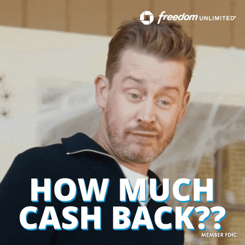 Sponsored gif. Actor Macaulay Culkin is wearing an orange and blue flannel shirt and waving awkwardly. The Chase Freedom Unlimited logo is in the upper right corner.  Additional text: "Happy Hanukkah!" 