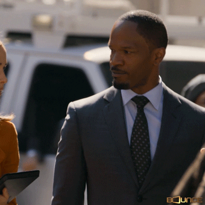 Celebrity gif. Jamie Foxx is walking down the street looking sharp in his suit and he gives us a thumbs up.