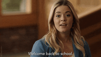 TV gif. An excited Sasha Pieterse as Alison on Pretty Little Liars looks around and says, “Welcome back to school.”