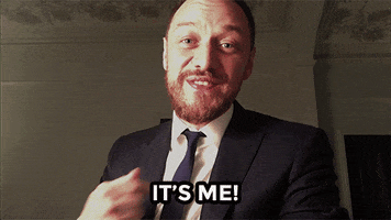 Celebrity gif. James McAvoy smiling and pointing at himself, then laughing. Text, "It's me!"