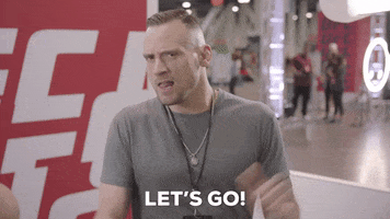 Sports gif. A man in a boxing gym pumps his fists in front of himself forcefully, saying, "Let's go!" which appears as text.