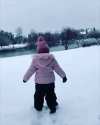 Child Plays as Snow Sprinkles Down Over Chicago