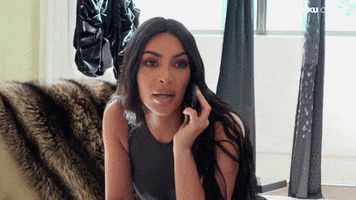 Celebrity gif. Kim Kardashian is on the phone and she looks at something and scrunches her nose and eyes in disgust, rejecting it.