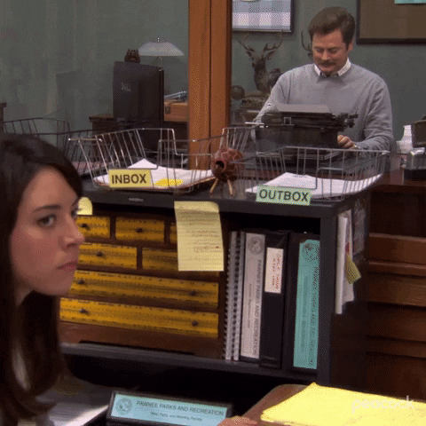 Parks and Recreation gif. Aubrey Plaza as April is sitting at her desk, turning slightly to look at us with subtle annoyance.