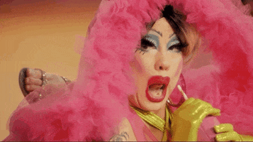 Reality TV gif. Willow Pill from RuPaul's Drag Race is watching something from the corner of their eye and they stick their tongue out to reach the straw in their cup, refusing to stop watching.