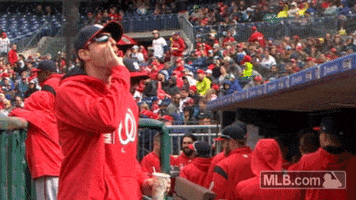 Sports gif. Max Scherzer of the Washington Nationals cups his hand around his mouth and boos around him.