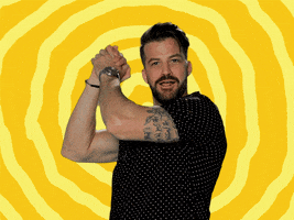 Video gif. Against a rippling, bright yellow background, TV personality Johnny Devenanzio clasps his hands together and assuredly shakes them from side to side.