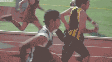Sports gif. Several men race on a track, and one man falls down, landing on his belly. The other racers continue on as the fallen man begins to do the worm instead of attempting to get up.