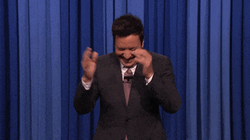 Tonight Show gif. Jimmy Fallon claps enthusiastically while looking down and laughing and he walks towards the camera as he claps. He blows a two handed kiss at us.