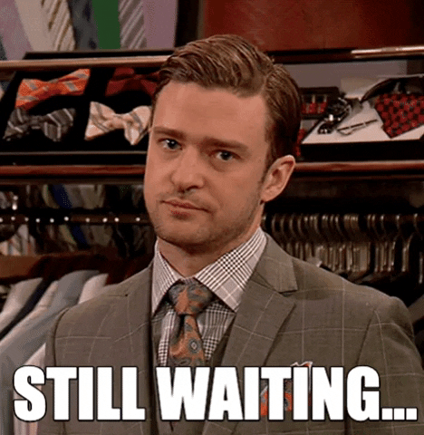 Celebrity gif. We zoom on Justin Timberlake as he tilts his head with an impatient stare. Text, "Still waiting."