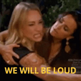 Reality TV gif. Angry Taylor Armstrong of Real Housewives of Beverly Hills screams and points a finger at someone as she is held back. Text, “We will be loud.”