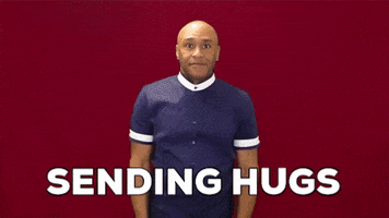 Video gif. A man wraps his arms around himself and hugs himself tight. Text, "Sending hugs."