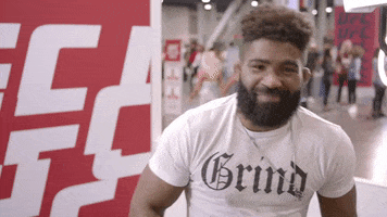 Sports gif. Chris Curtis in a gym, smiling and gesturing at his neck to cut it out.