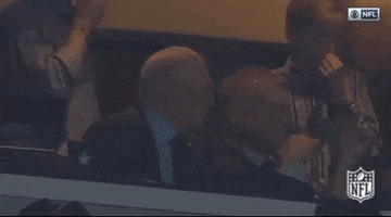 Sports gif. Jerry Jones, owner of the Dallas Cowboys, is sitting his booth and he suddenly leans back and clutches his face in his hands.