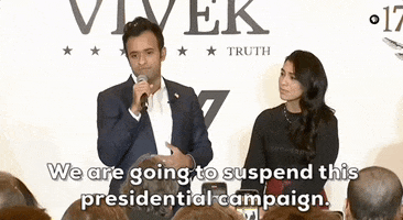 Political gif. Vivek Ramaswamy stands in front of a crowd and speaks into a microphone, saying, "We are going to suspend this presidential campaign," which appears as text. He looks very disappointed as he addresses the crowd and he has his hand on his chest.