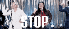 Music video gif. The Spice Girls from the video for Stop, singing and gesturing, stretching out, palms faced out to us. Text, "Stop!"