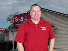 Ad gif. Brian Layton stands in front of an image of his store, SoundFX Automotive, as he smiles at us and raises his arms, seeming to hold up the flaming and glowing graphic that says, "Amazing!" 